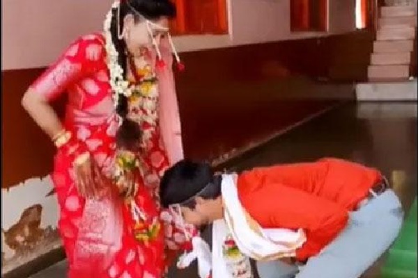 Groom takes blessings from wife