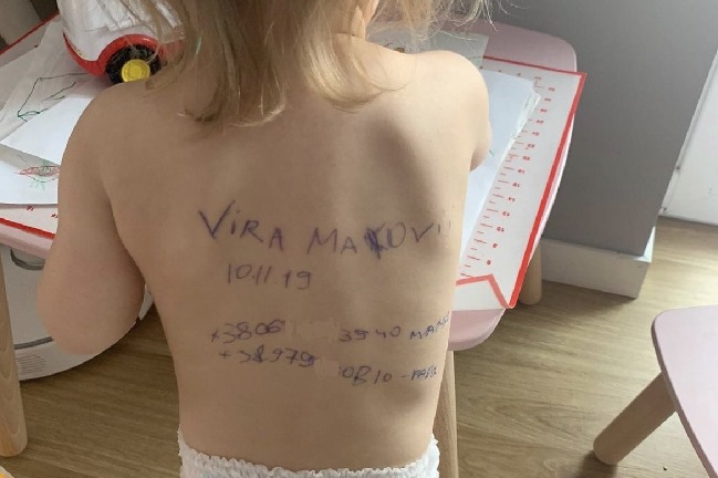 Ukraine Mothers writing family details on their children back