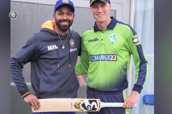 Hardika Panda presents his bat to Irish young cricketer Harry Tector