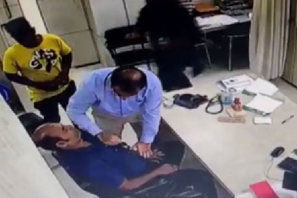 Doctor performs CPR on patient as he suffers heart attack in the clinic