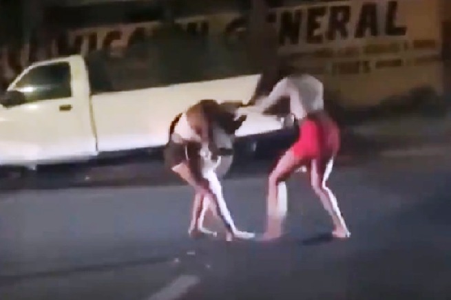 Two women fight violently on a busy street