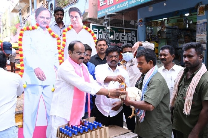 a trs leader distributes a hen and a quarter liquor bottle to poor in warangal