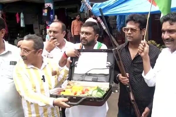 Cong workers buy tomatoes carrying briefcase and gun to protest against price rise