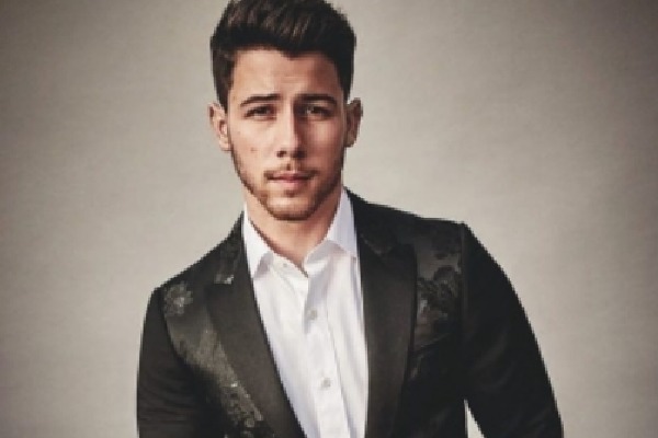 Nick Jonas falls through hole on stage while performing