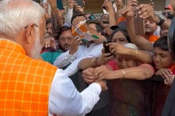 Woman ties rakhi to PM Modi as huge crowd gathers outside polling booth in Ahmedabad