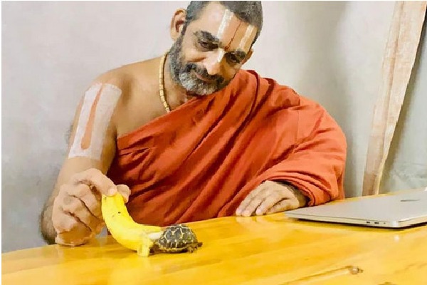 Chinna Jeeyar Swamy feeds a tortoise in his Ashram