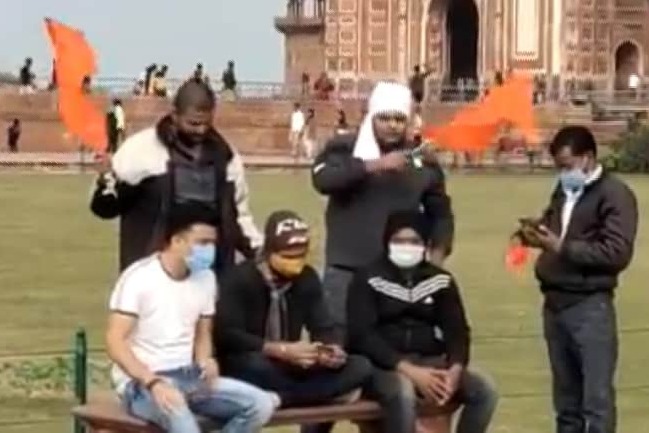 Youth held waving saffron flags at Taj Mahal