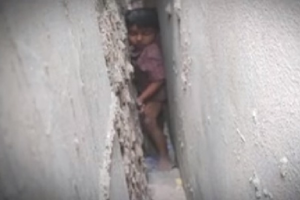 Two children get stuck in between narrow walls 
