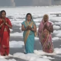 Few Chhath devotees stand in toxic foam laden Yamuna river near Delhis Kalindi Kunj to offer prayers to the Sun god