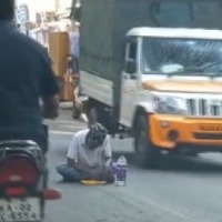 man eats tiffin on road 