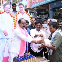 a trs leader distributes a hen and a quarter liquor bottle to poor in warangal