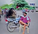 man sits on chair with parked bike in the middle of road in delhi for reel