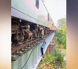 locopilots repain engine while dangling from bridge