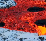 fire vs ice lava oozing over snow in Iceland