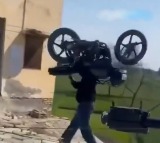 Man lifts his bike to cross a railway gate
