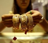 Gold edges lower on stronger dollar, Fed minutes weigh on rate-cut hopes