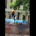 Water Tanker driver cleans his legs while standing upon the tanker