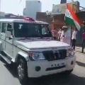 People shower flowers at police vehicles in Meerut